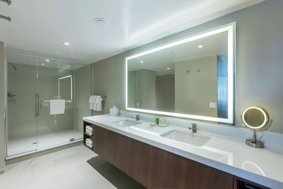 Bathroom in a two-bedroom bi-level suite at Caribe Hilton with double vanity and glass shower.