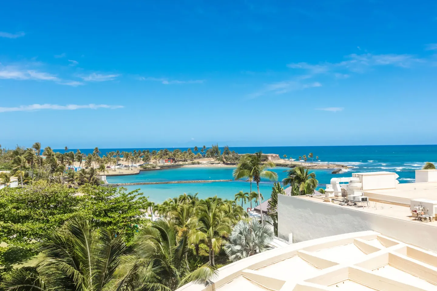 Ocean, lagoon, palms, and rooftops viewed from Caribe Hilton.