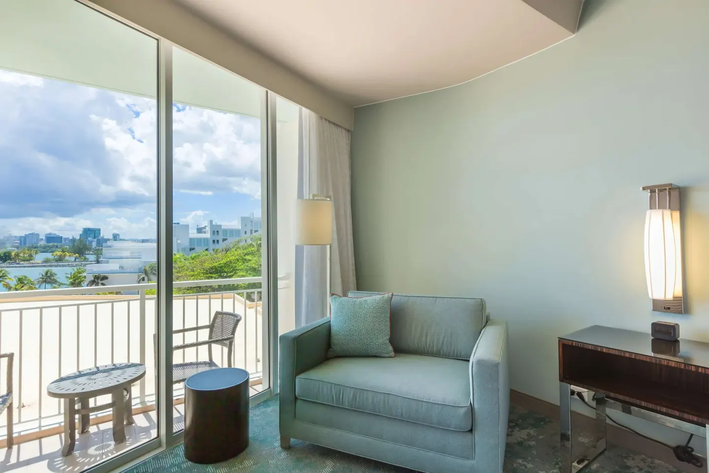 Light blue sofa beside balcony doors in a guest room at Caribe Hilton.