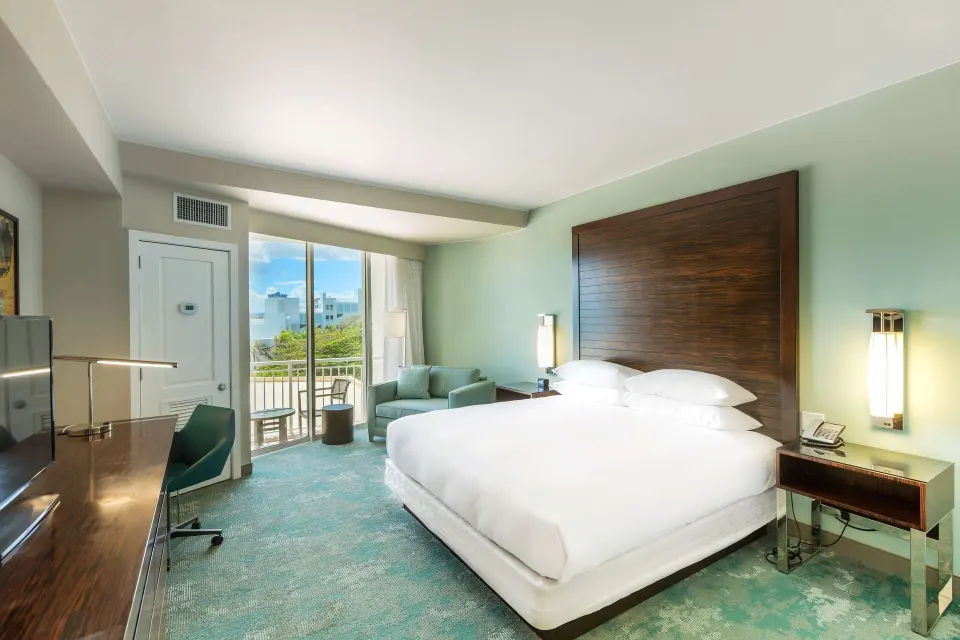 King guest room with balcony, desk, and seating at Caribe Hilton.