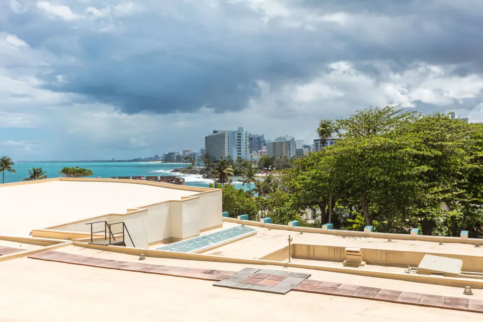 Resort and ocean view from a king guest room at Caribe Hilton under cloudy skies.