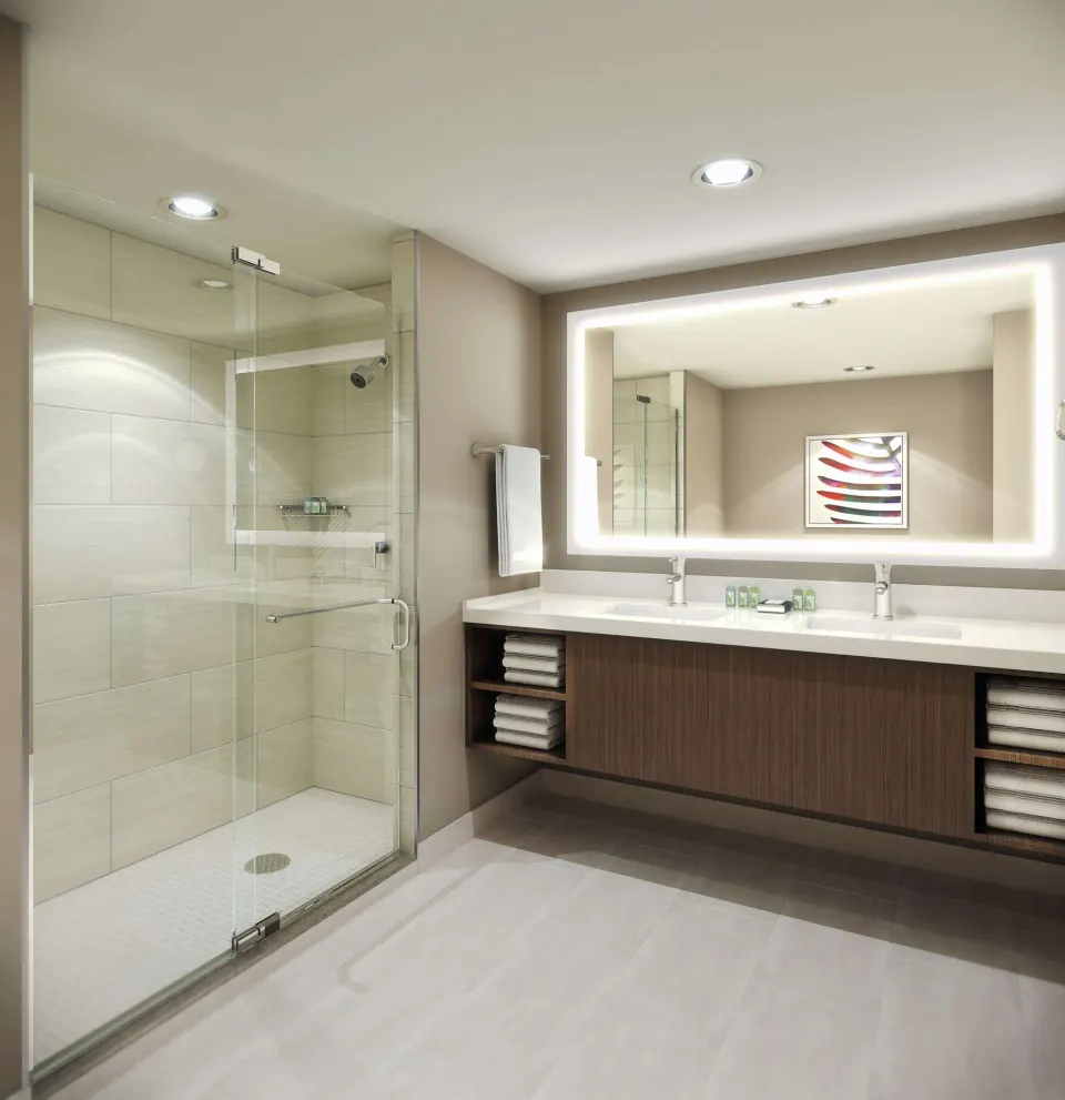 Guest bathroom with glass shower and double vanity at Caribe Hilton.