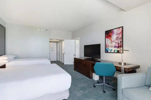 Family Connecting Junior Suite beds, desk, TV, and sofa at Caribe Hilton.