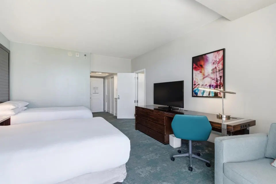 Family Connecting Junior Suite beds, desk, TV, and sofa at Caribe Hilton.