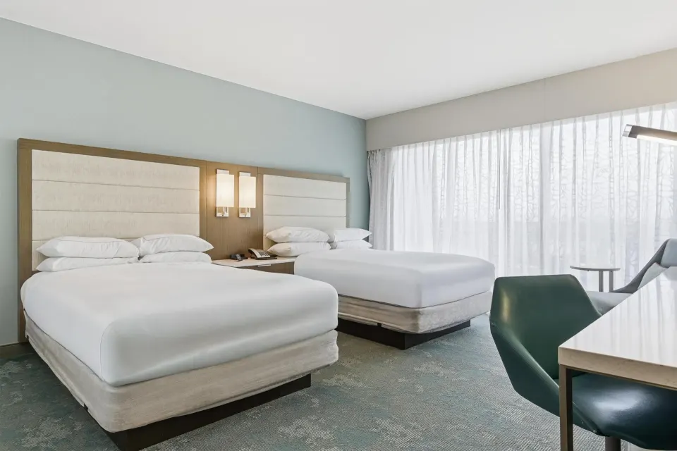 Family Room Garden View with two beds, sheer curtains, and a desk chair at Caribe Hilton.
