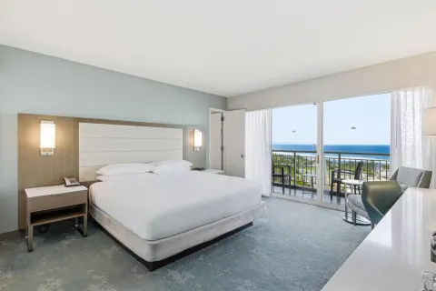 Family Room Ocean View king bed with balcony and ocean beyond at Caribe Hilton.