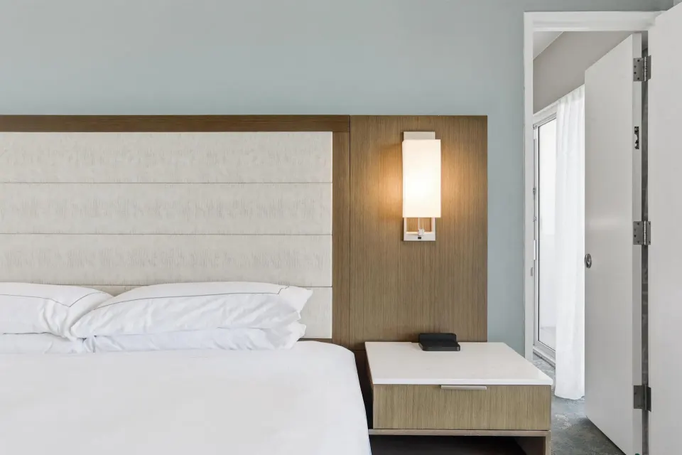 Close-up of the Family Room Ocean View king bed and nightstand at Caribe Hilton.