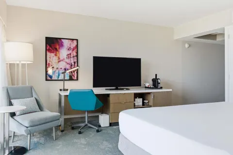 Family Room Ocean View sitting area with TV, desk, and lounge chair at Caribe Hilton.