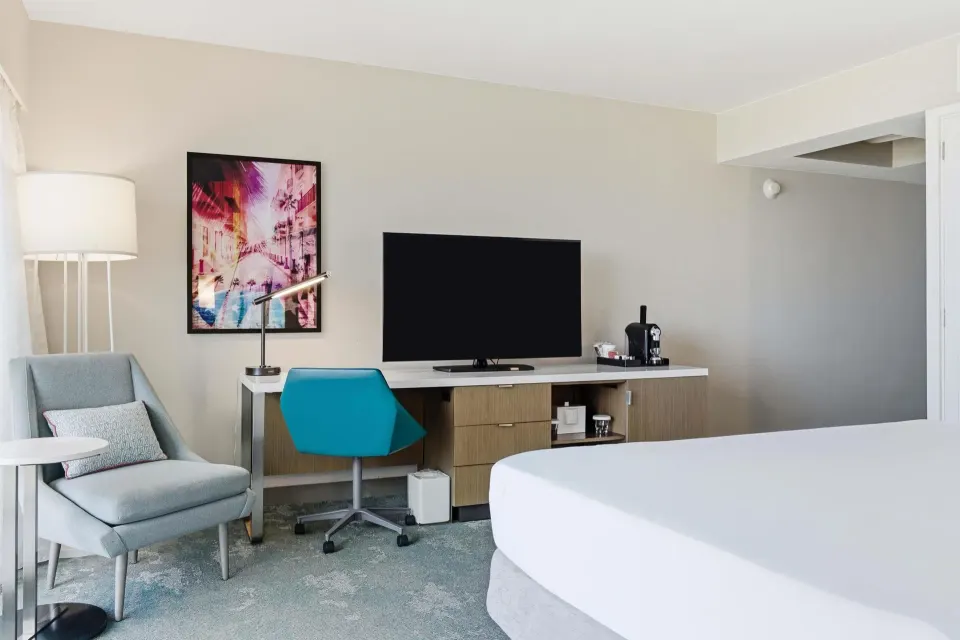 Family Room Ocean View sitting area with TV, desk, and lounge chair at Caribe Hilton.