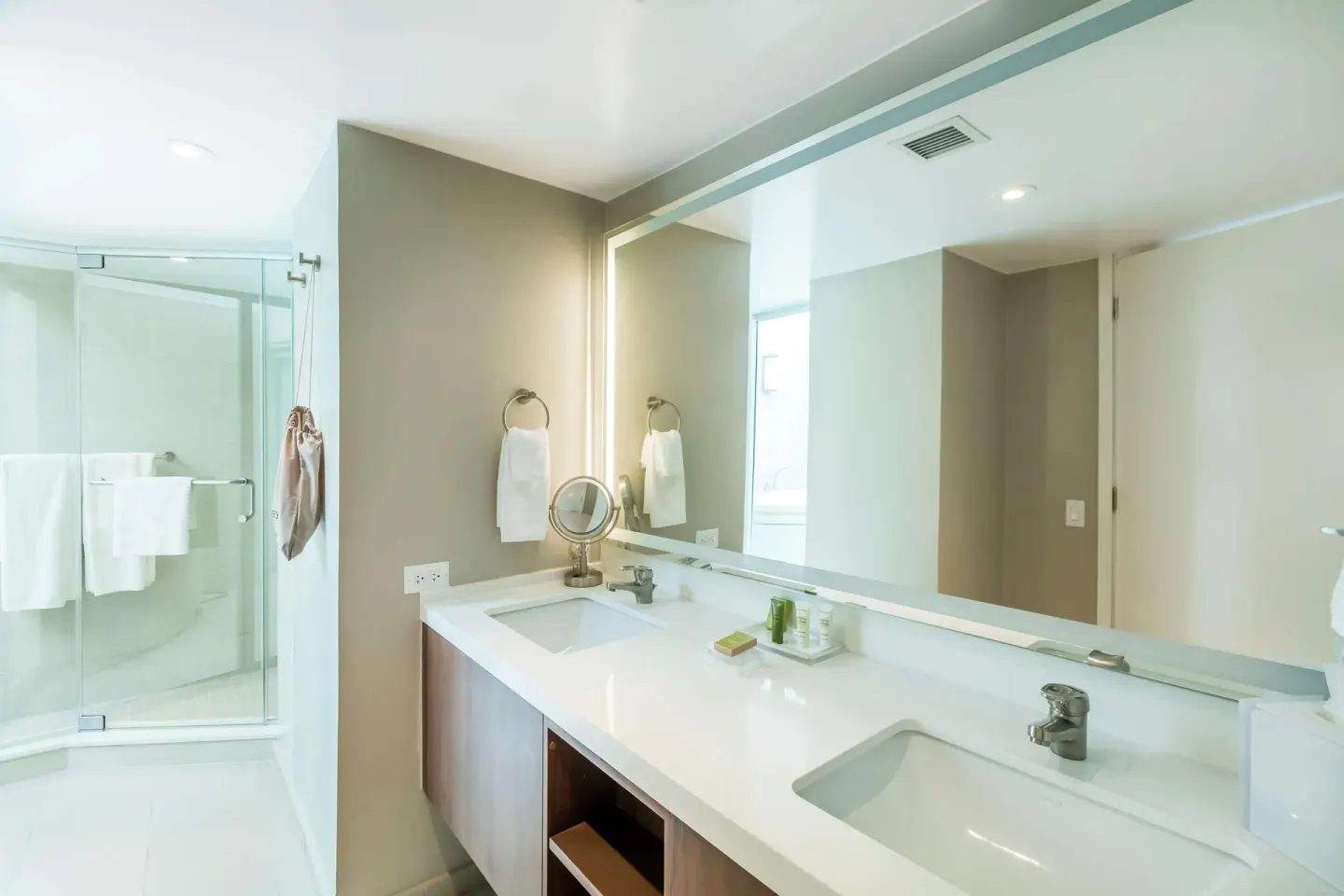 Honeymoon suite bathroom with double vanity and glass shower at Caribe Hilton.