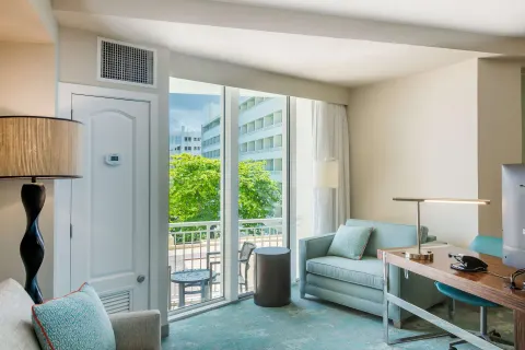 Junior suite living area with balcony seating and desk at Caribe Hilton.