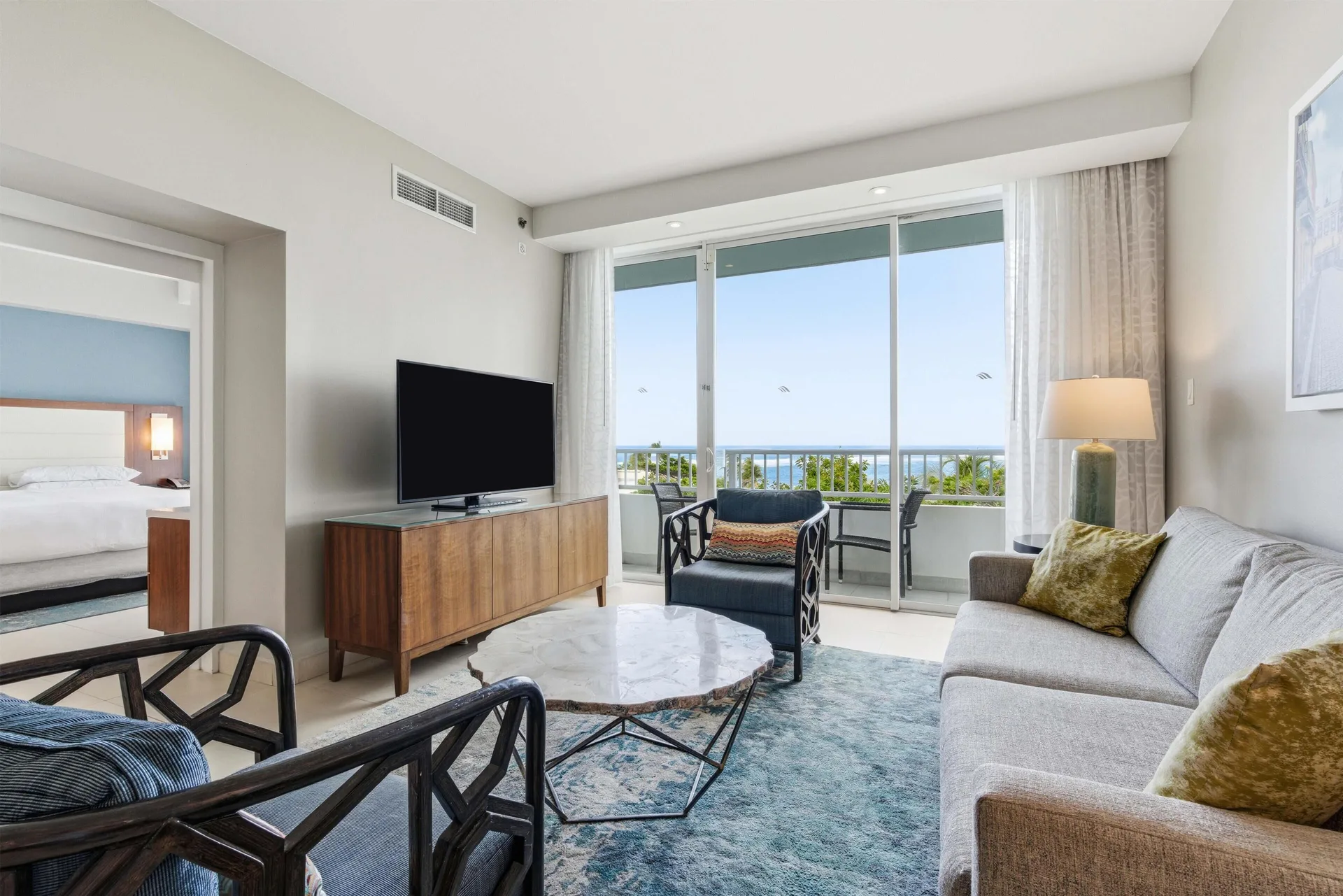 Premium Suite living room with balcony and bedroom doorway at Caribe Hilton.