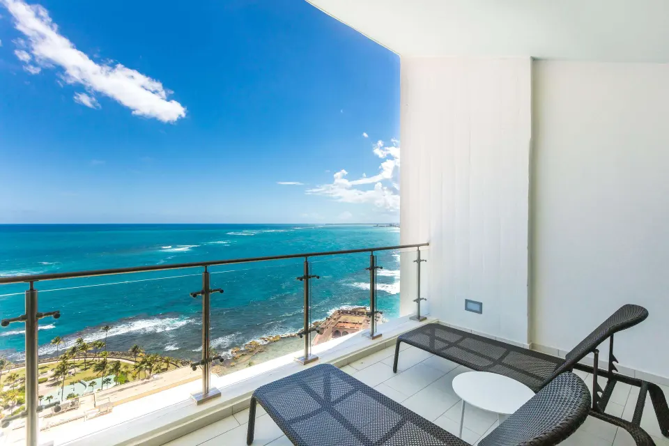 Presidential suite balcony with lounge chairs and ocean view at Caribe Hilton.
