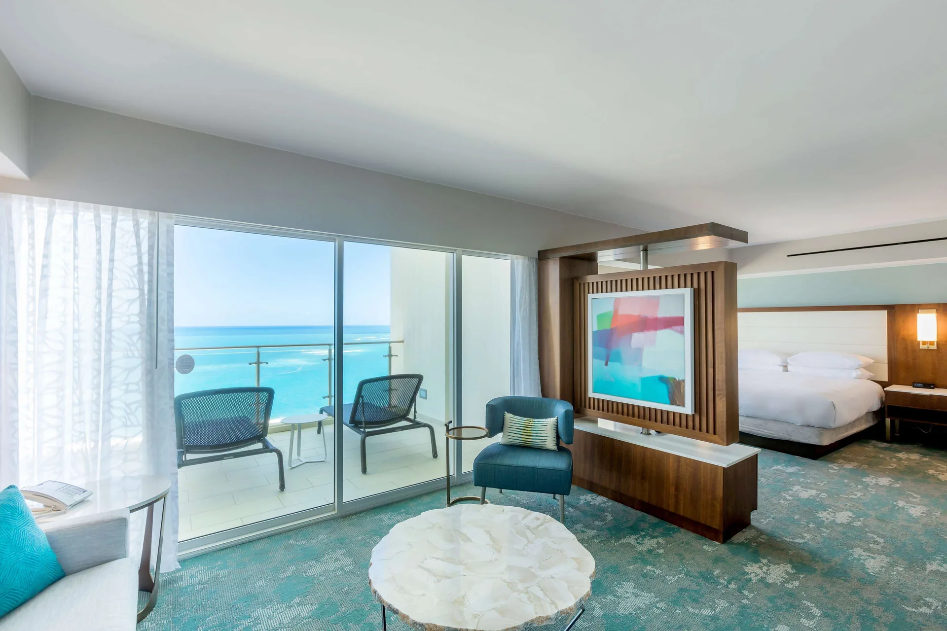 Presidential 2 Bedroom Suite Ocean View living area at Caribe Hilton with king bed, upscale furnishings, and panoramic Atlantic Ocean views in San Juan.