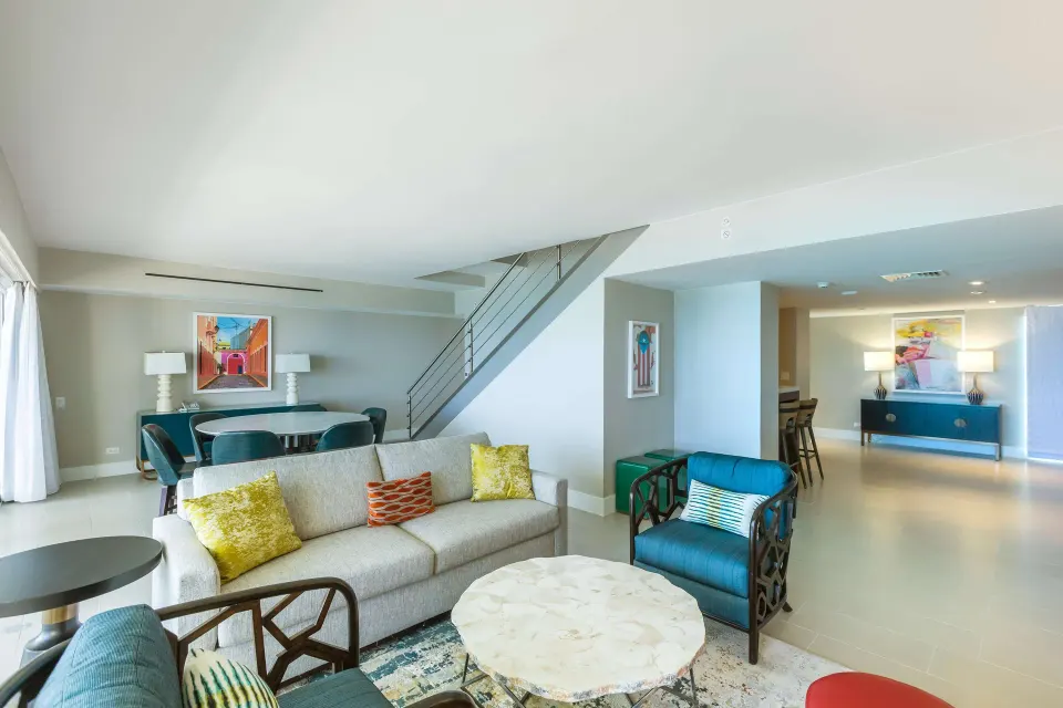 Presidential suite living and dining area with staircase at Caribe Hilton.