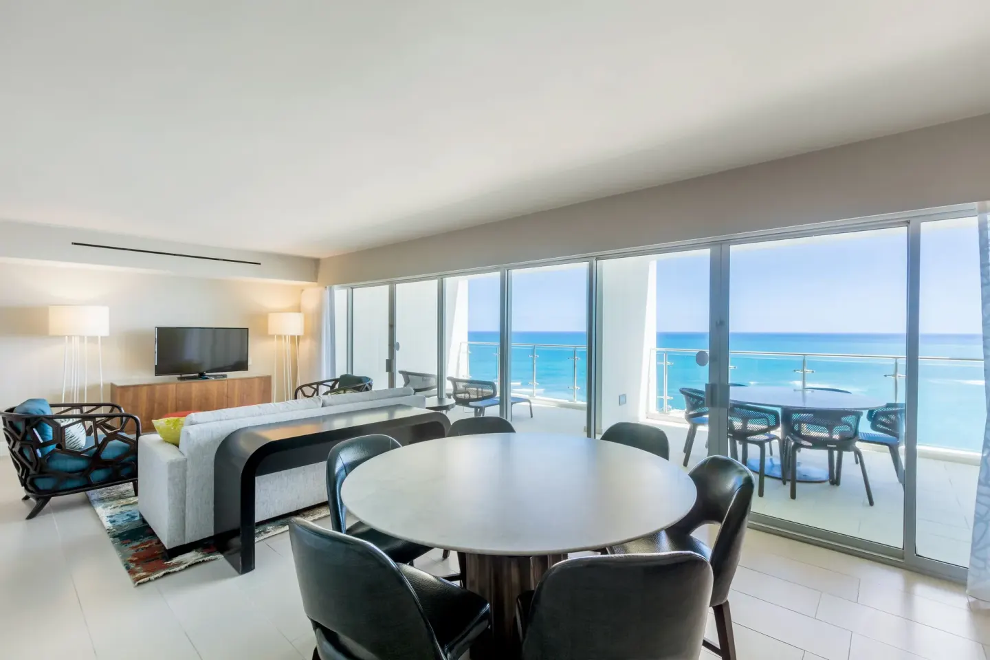 Ocean-view living and dining room with balcony in the Presidential suite at Caribe Hilton.