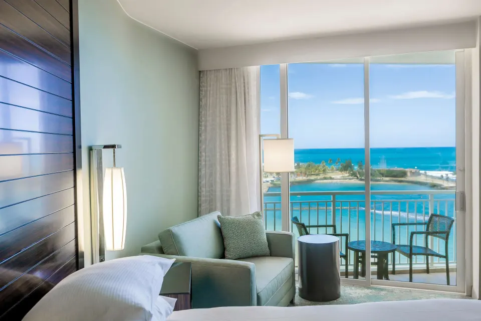 King guest room seating area and balcony ocean view at Caribe Hilton.