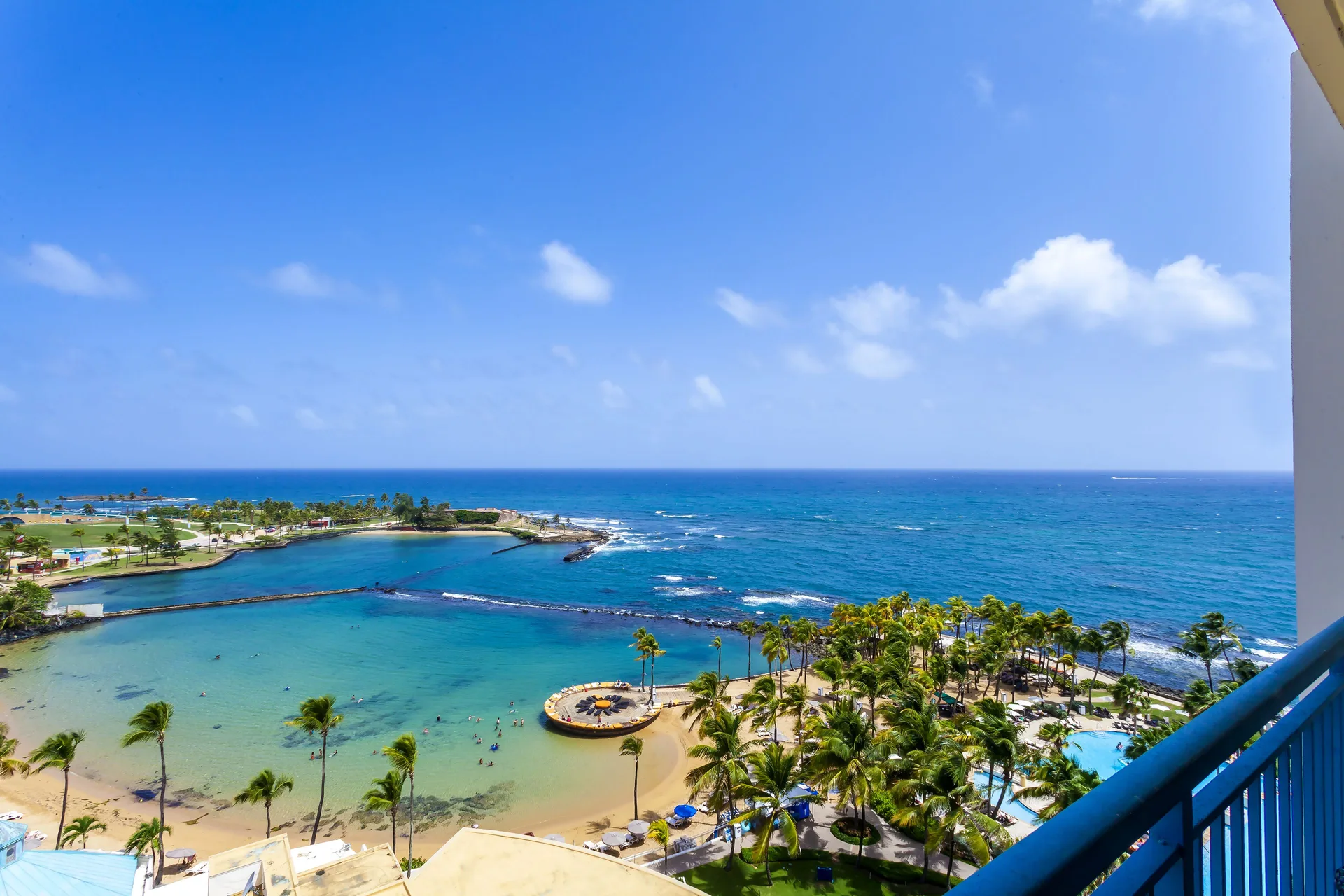 Premium Ocean View king room balcony view of beach, pool and ocean at Caribe Hilton.