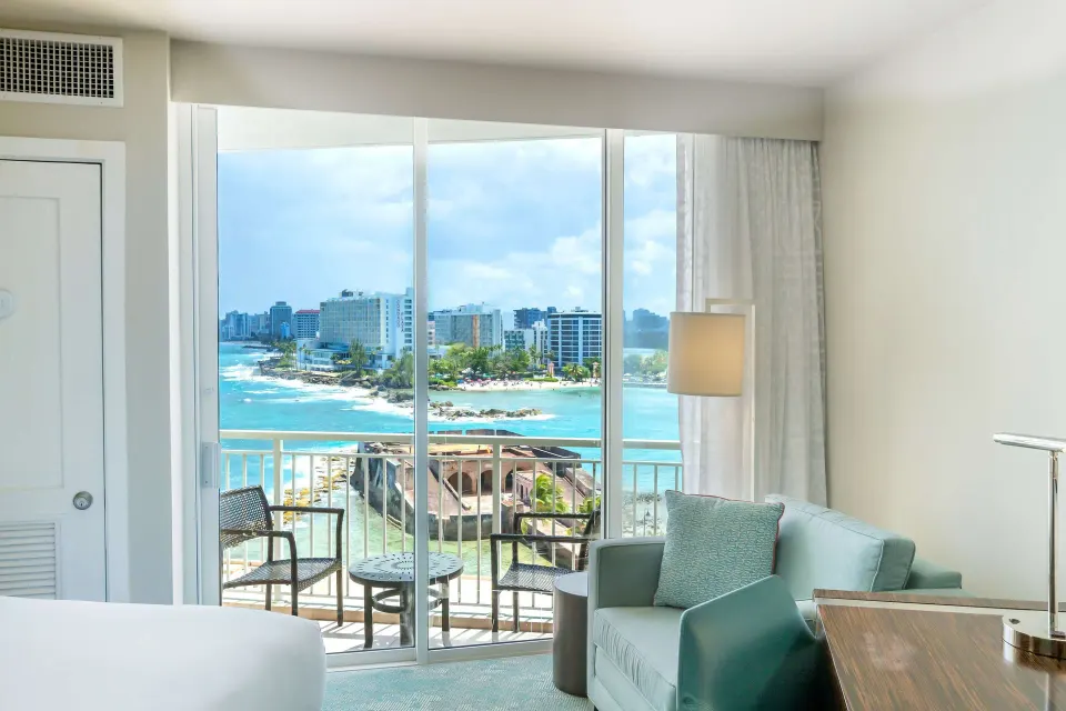 Premium ocean view double room balcony and seating area at Caribe Hilton.