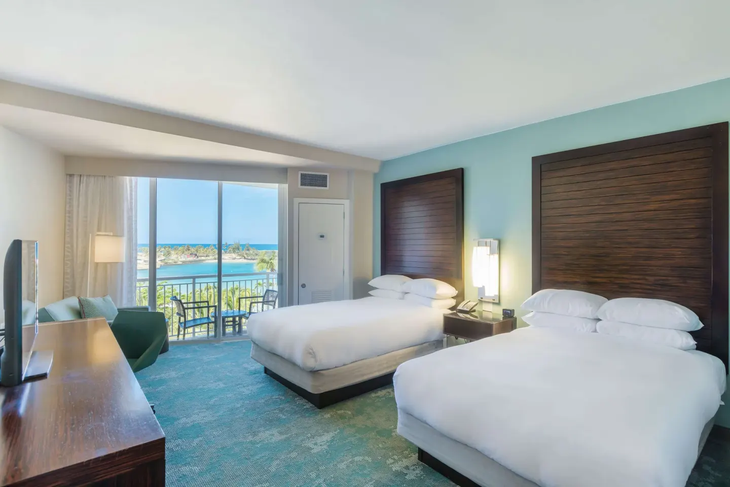 Premium ocean view room with two double beds and balcony at Caribe Hilton.