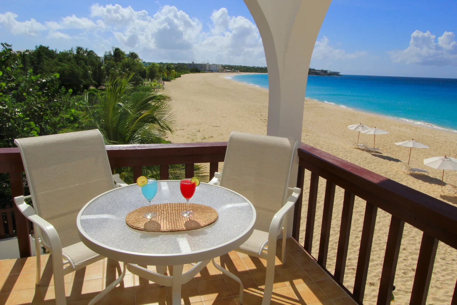 Balcony table and chairs overlook the beach and turquoise water at Carimar Beach Club.