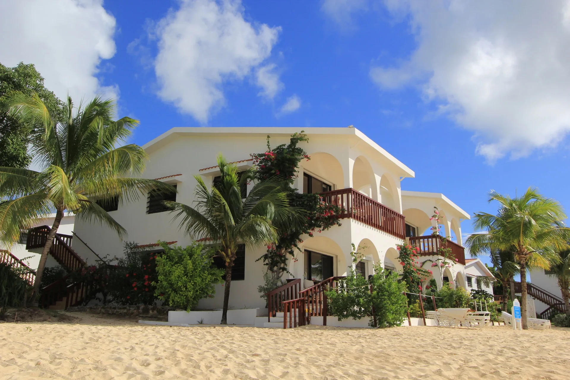 White resort buildings with balconies beside the sand at Carimar Beach Club.