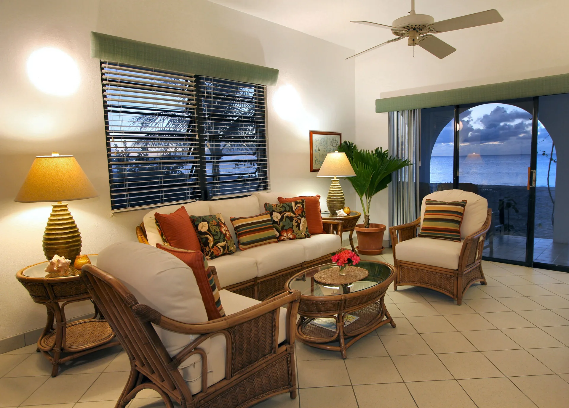 Living room with wicker seating and ocean-facing glass doors at Carimar Beach Club.