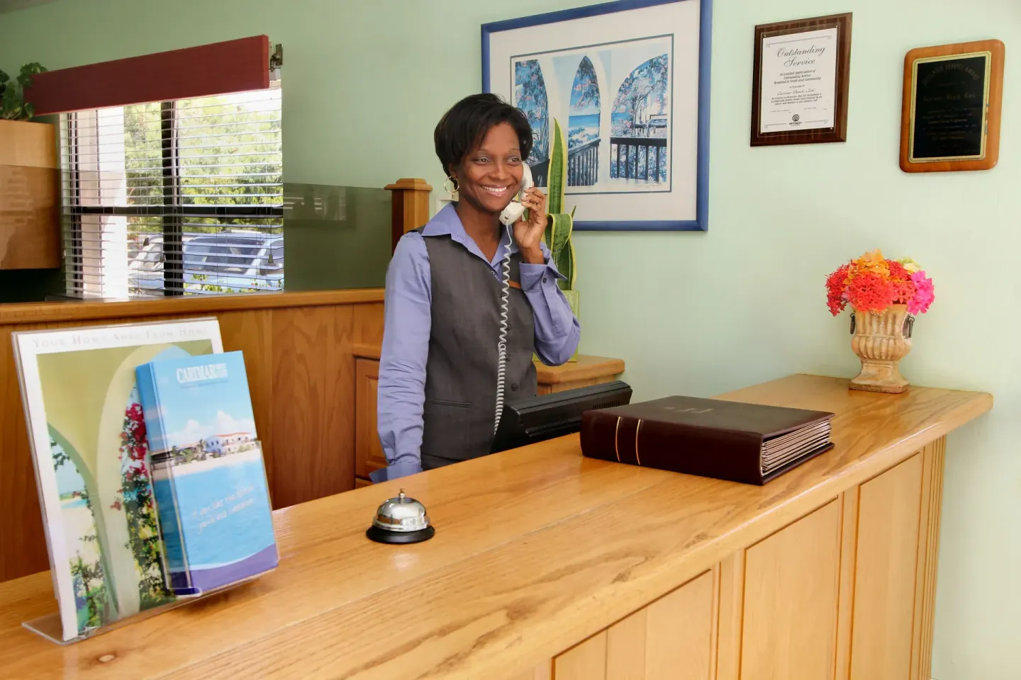 Reception desk with staff member on the phone at Carimar Beach Club.