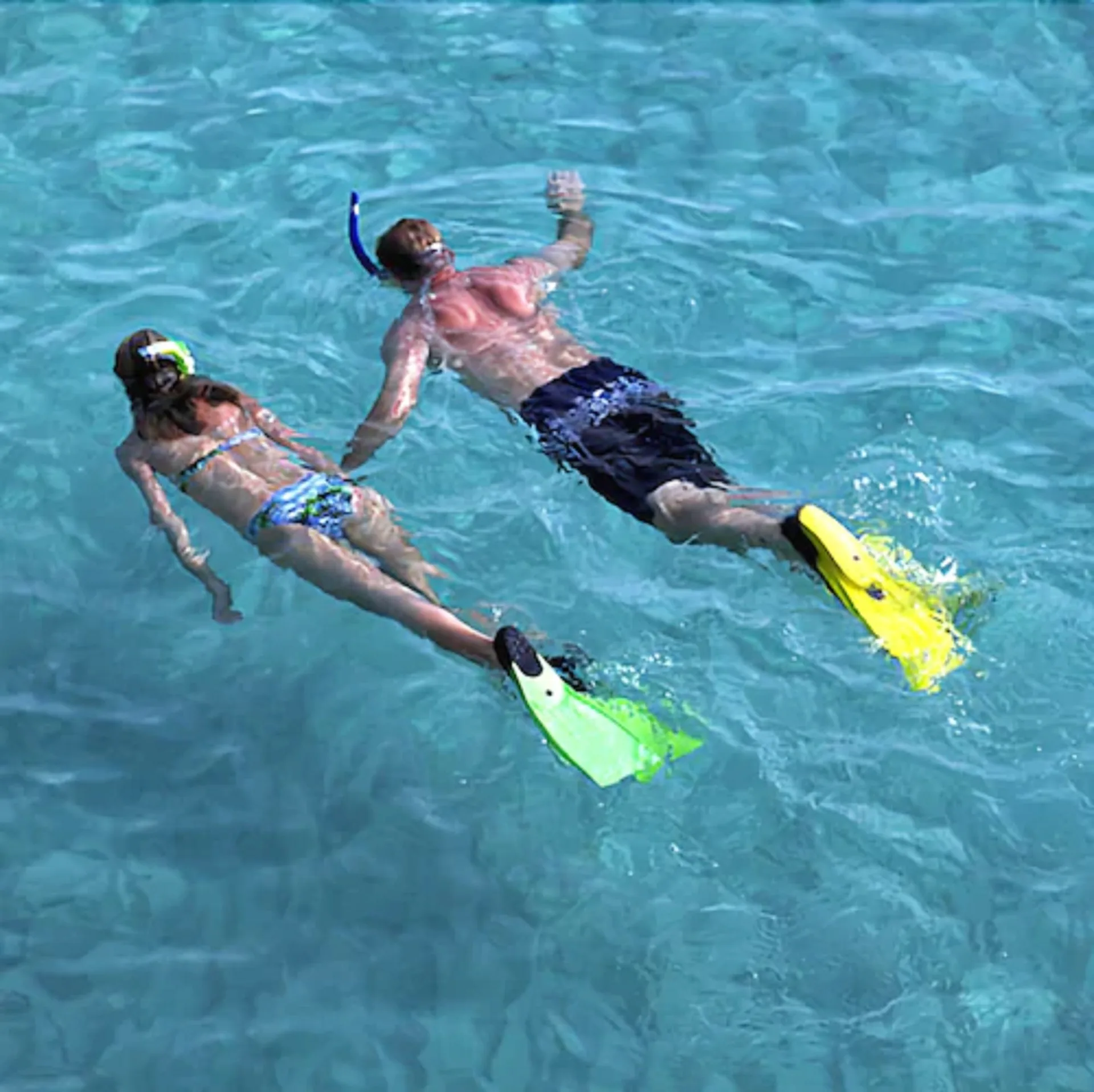 Two snorkelers with fins float in clear blue water near Carimar Beach Club.