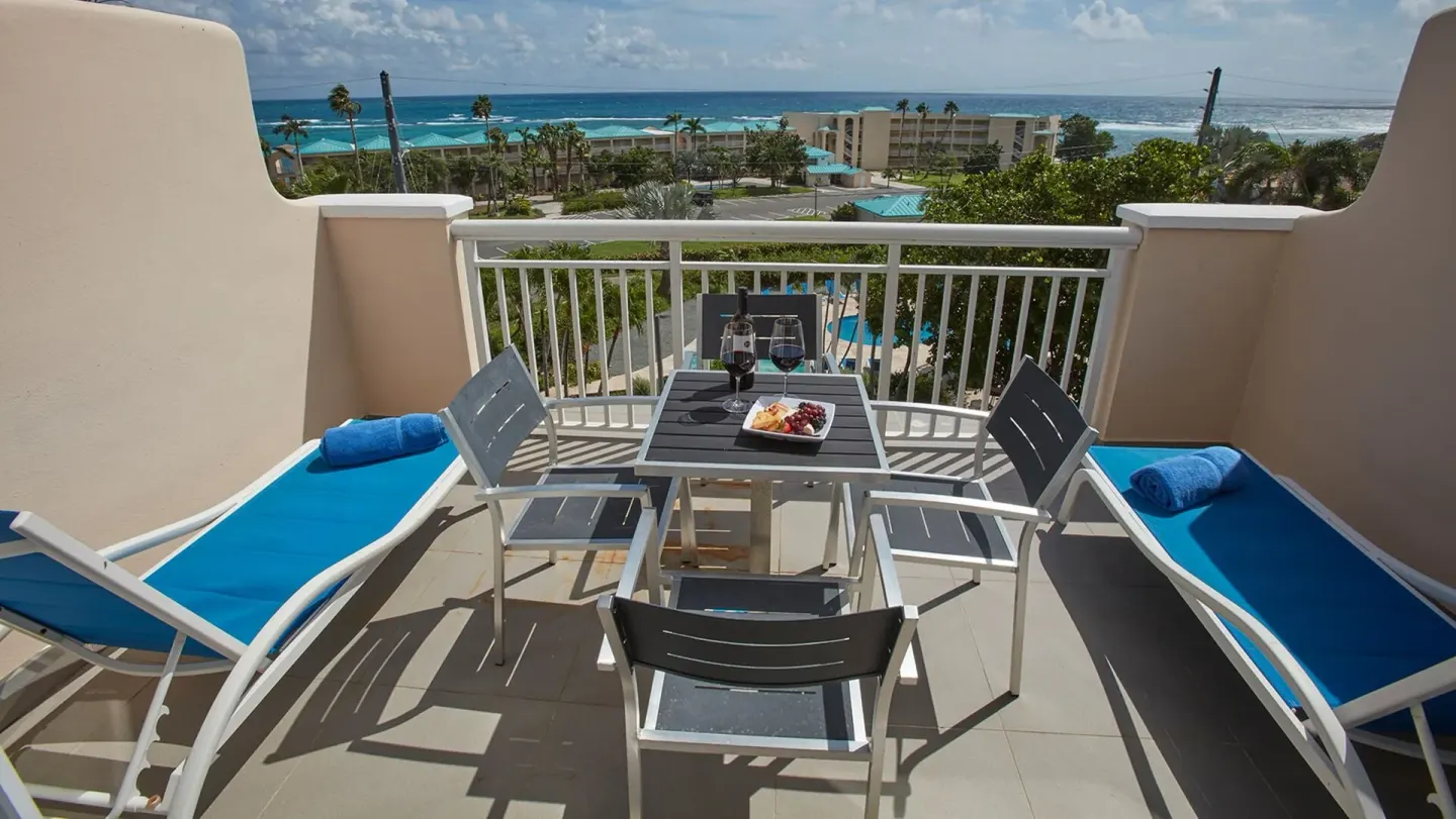 Balcony loungers and dining table at Carina Bay Boutique Resort & Casino.