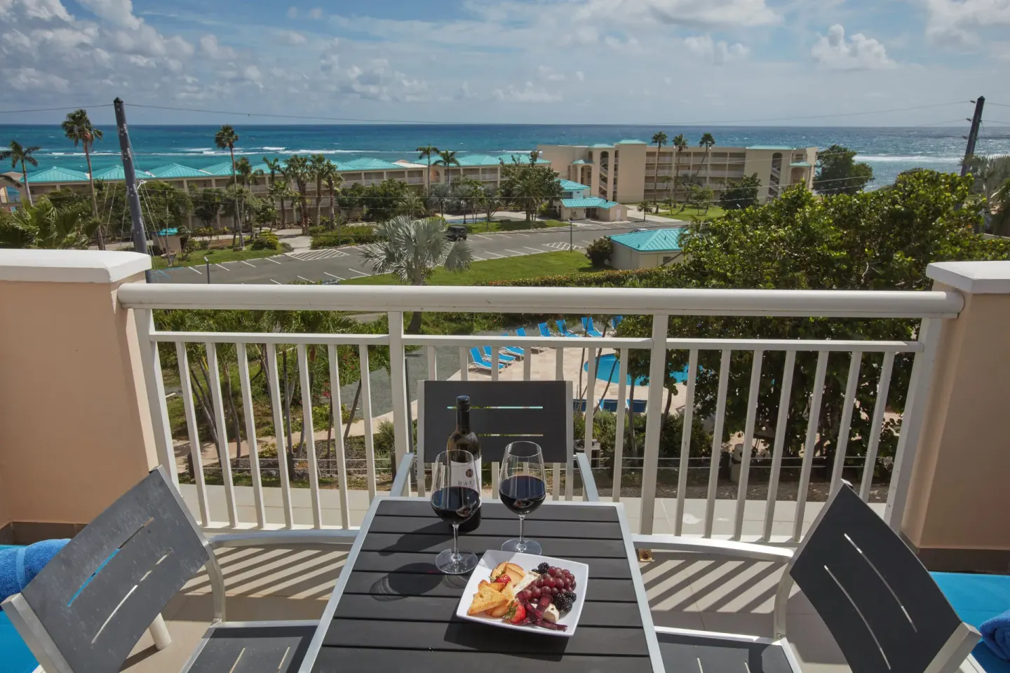Balcony table with wine and snacks overlooking the resort at Carina Bay Boutique Resort & Casino.