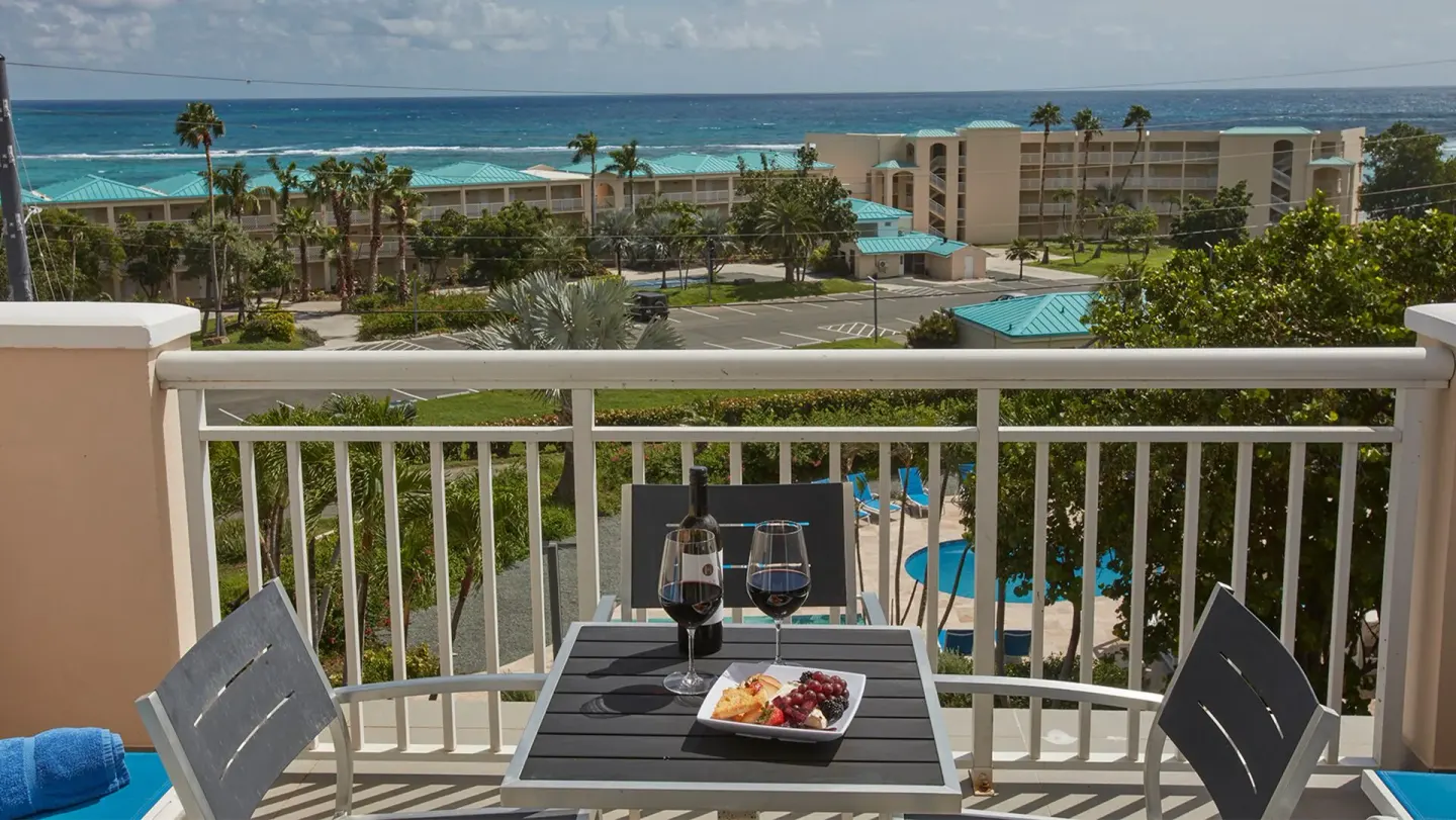 Balcony table with ocean and resort views at Carina Bay Boutique Resort & Casino.