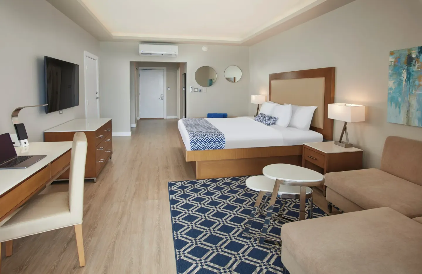 King bed guest room with seating area at Carina Bay Boutique Resort & Casino.
