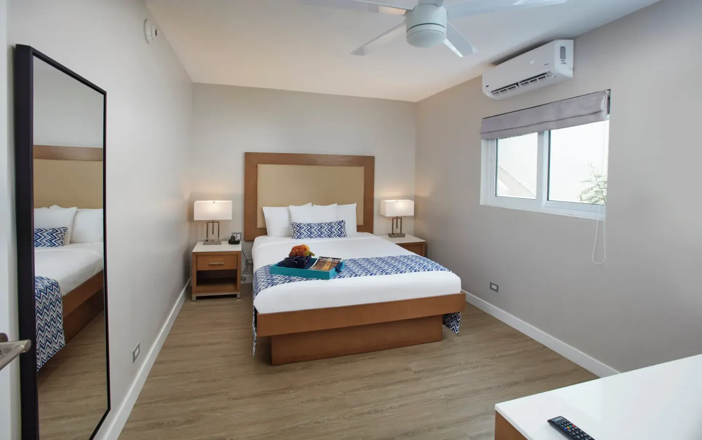 Bedroom with one bed and wall mirror at Carina Bay Boutique Resort & Casino.