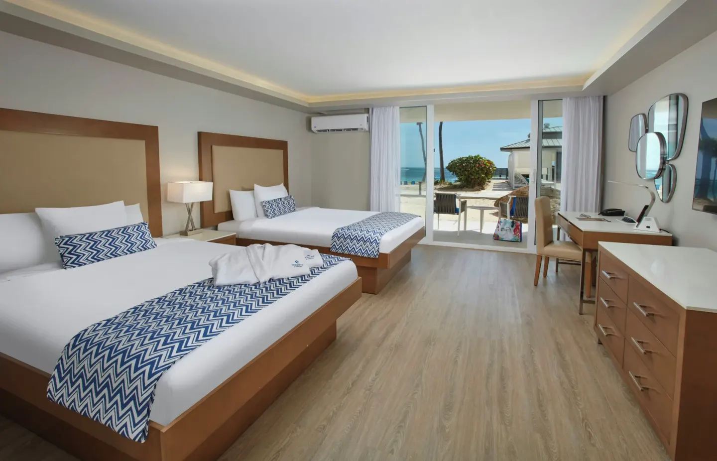 Guest room with two beds and patio view at Carina Bay Boutique Resort & Casino.