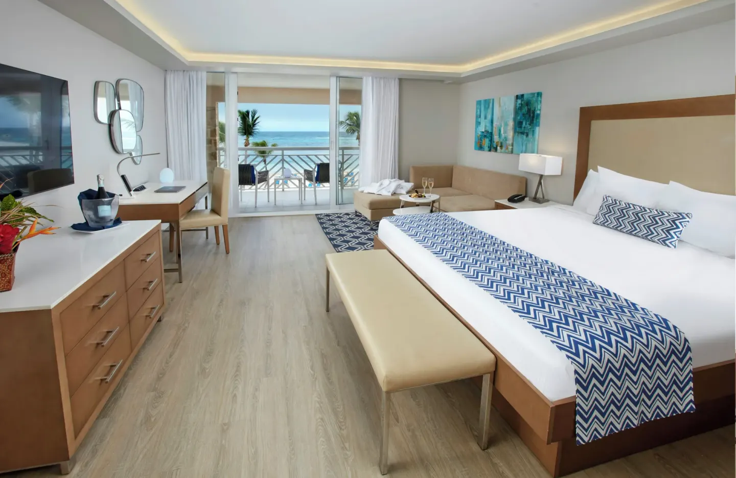 King bed guest room with balcony and ocean view at Carina Bay Boutique Resort & Casino.