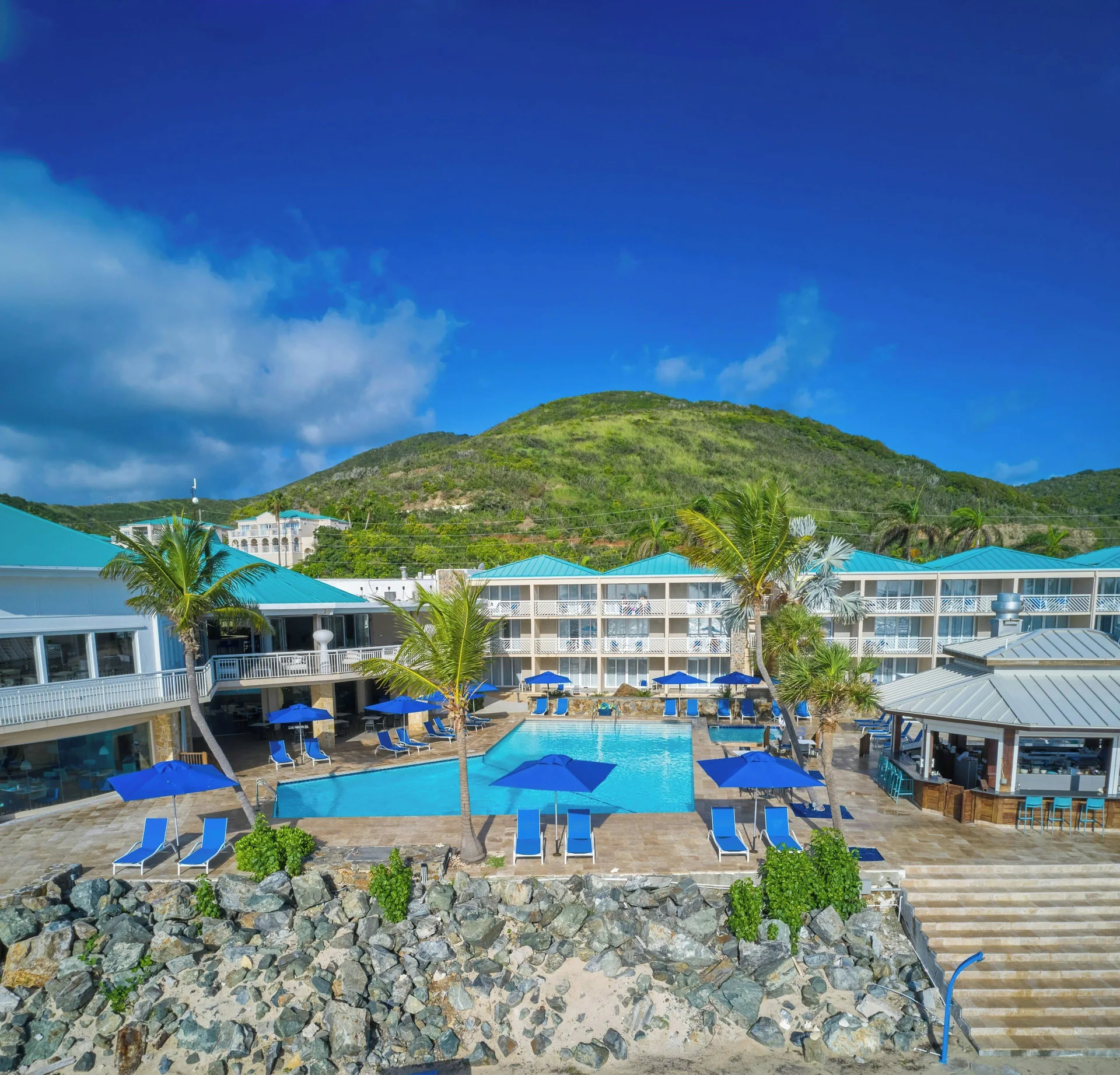 Oceanfront pool deck and resort buildings at Carina Bay Boutique Resort & Casino.