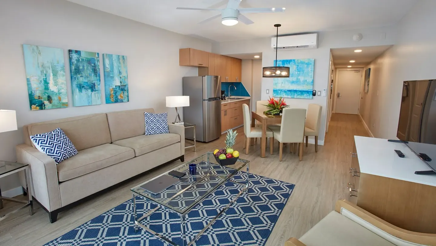 Suite living and dining area with kitchenette at Carina Bay Boutique Resort & Casino.