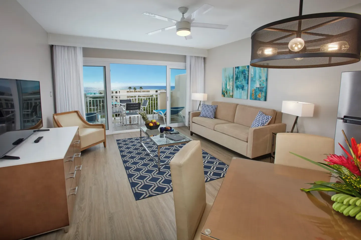Suite living room with sofa and balcony view at Carina Bay Boutique Resort & Casino.