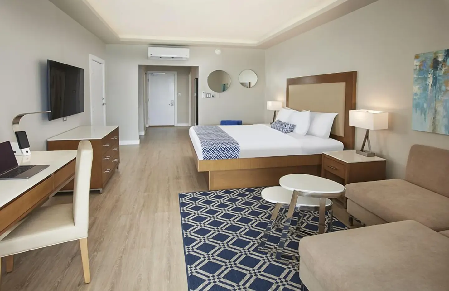 Beachfront king guest room with seating area at Carina Bay Boutique Resort & Casino.