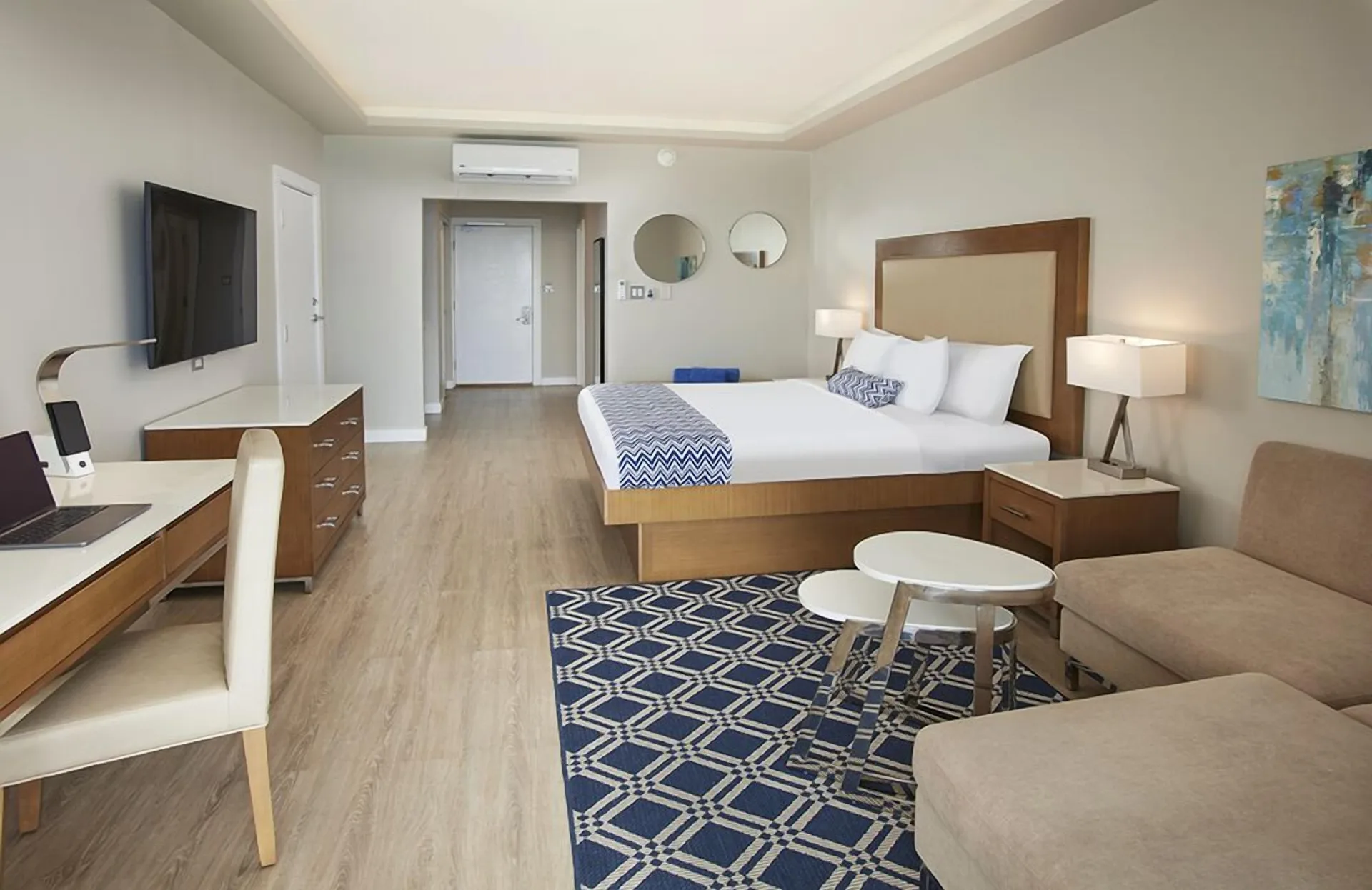 Beachfront king guest room with seating area at Carina Bay Boutique Resort & Casino.