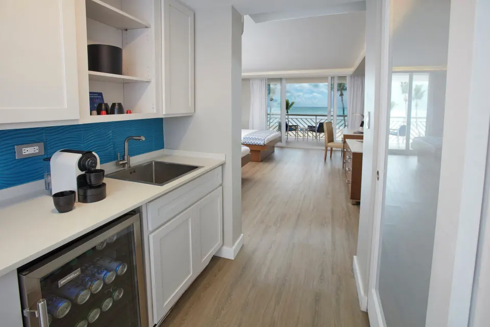 Beachfront room kitchenette and hallway toward balcony at Carina Bay Boutique Resort & Casino.