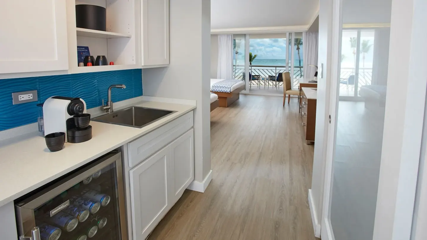 Beachfront room kitchenette with balcony view at Carina Bay Boutique Resort & Casino.