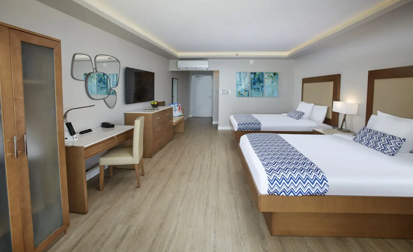 Beachfront two-bed room with desk and dresser at Carina Bay Boutique Resort & Casino.