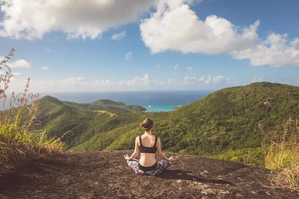 A guest meditates on a hilltop overlooking the coast near Carlisle Bay.