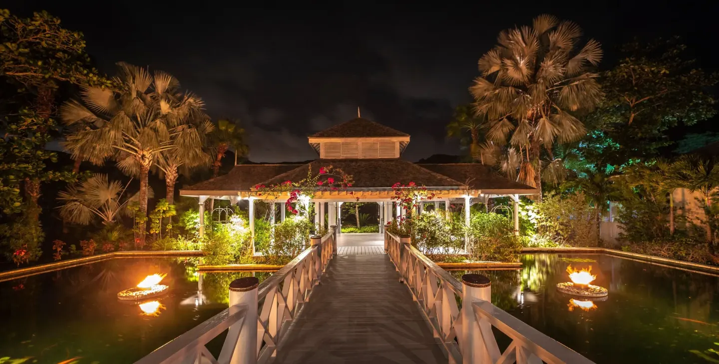 Illuminated walkway over water leading to a pavilion at Carlisle Bay.
