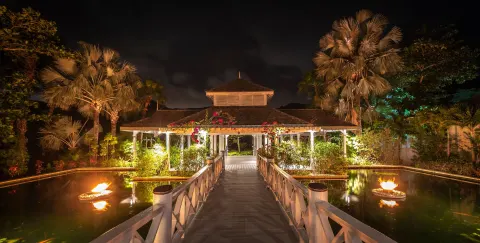 Illuminated walkway over water leading to a pavilion at Carlisle Bay.