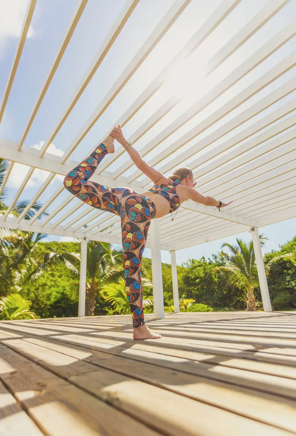 A guest practices yoga on a sunlit deck at Carlisle Bay.
