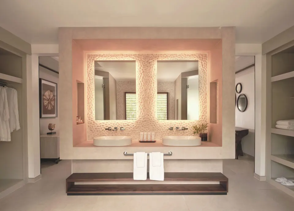 Bay Suite bathroom vanity with double sinks and illuminated mirrors at Carlisle Bay.