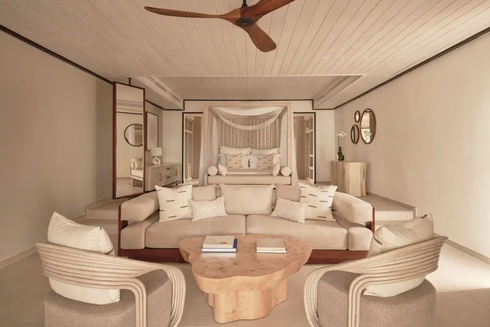 Bay Suite lounge and canopy king bed in an open-plan room at Carlisle Bay.